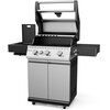 Srebrny grill gazowy z czterema pokrętłami na panelu przednim, posiadający zamykaną pokrywę i boczne półki. Na panelu widoczny jest napis "KOLER Krone Compact Pro".
