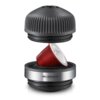 Czarny adapter z napisem "NS CAPSULES ADAPTER" jest pokazany w dwóch częściach, pomiędzy którymi znajduje się czerwona kapsułka. Górna część adaptera ma żebrowaną powierzchnię, a dolna jest gładka z metalicznym wykończeniem.