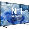 Telewizor z cienką ramką, na ekranie widoczna jest grafika z niebieskimi i białymi wzorami oraz tekst: "SAMSUNG Nr 1 NA ŚWIECIE Najczęściej kupowane telewizory od 19 lat QLED".