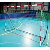 Na zdjęciu znajduje się bramka do piłki ręcznej z czerwono-białymi słupkami i siatką, ustawiona na niebieskiej hali sportowej z widocznymi liniami boiska. Na słupku widoczny jest napis "QUICKPLAY".