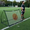 Na zdjęciu znajduje się trenażer do piłki nożnej QUICKPLAY Spot Rebounder o wymiarach 150 x 100 cm, ustawiony na boisku piłkarskim. Na siatce widoczny jest czerwony cel, a na ramie znajduje się logo "QUICKPLAY".