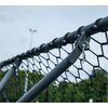 Zbliżenie na metalową ramę trenażera do piłki nożnej z siatką przymocowaną za pomocą plastikowych uchwytów. W tle widoczne są rozmyte drzewa i słup oświetleniowy na tle nieba.