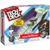Opakowanie produktu "Tech Deck Nyjah Skatepark" przedstawia model skateparku z rampą, schodami i zieloną poręczą, a także miniaturową deskorolkę. Na opakowaniu widnieją napisy: "MASSIVE! MODULAR SKATEPARK", "Signature board INCLUDED!", "WARNING: Choking h