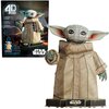 Pudełko z puzzlami 3D przedstawia postać z dużymi uszami i zieloną skórą, ubraną w beżowy strój, z napisem "4D Build" oraz "Star Wars" na opakowaniu. Obok pudełka znajduje się złożony model tej samej postaci, stojący na podstawce z logo "Star Wars".