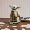 Na zdjęciu znajduje się model 3D przedstawiający postać z dużymi uszami, zbudowany z elementów puzzli, stojący na podstawce z napisem "Star Wars Grogu". Wokół modelu leżą rozłożone elementy puzzli oraz instrukcja montażu.