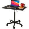 Czarny stolik na kółkach z regulowaną wysokością, na którym znajduje się otwarty laptop z kolorowym ekranem, czerwona filiżanka oraz talerzyk z rogalikiem. Stolik ma prostokątny blat i pięcioramienną podstawę.