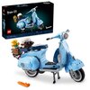 Na zdjęciu znajduje się niebieski model skutera z klocków, z białym kaskiem i kwiatami w koszyku z tyłu. W tle widoczne jest opakowanie z napisem "Vespa 125", logo "Vespa" oraz "LEGO", a także oznaczenia "18+", "10298", "1106 pcs".