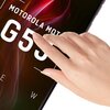Na zdjęciu widoczny jest fragment ekranu telefonu z wyświetlonym tekstem "MOTOROLA MOTO G55". Na ekranie znajduje się dłoń dotykająca jego powierzchni.