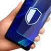 Na zdjęciu widać dłoń trzymającą smartfon z nałożonym szkłem ochronnym, na ekranie którego widoczna jest grafika z tarczą. Szkło ochronne jest przezroczyste, a tło ekranu ma niebieskie, faliste wzory.