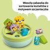 Na zdjęciu znajduje się zabawka do sortowania kształtów z motywem szczeniaczka, składająca się z kolorowych klocków i okrągłej podstawy z otworami. Na górze zdjęcia widnieje tekst: "Wesoła zabawka do sortowania kształtów z motywem szczeniaczka".