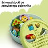 Na zdjęciu znajduje się okrągły pojemnik wypełniony kolorowymi klockami LEGO, z widocznymi motywami, takimi jak piesek i jabłka. Na górze zdjęcia widnieje tekst: "Schowaj klocki do zamykanego pojemnika".