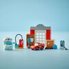 Zestaw LEGO przedstawia warsztat z czerwono-szarym budynkiem, samochodem wyścigowym i różnymi akcesoriami. Na jednym z elementów widoczny jest napis "DOCTOR HUDSON".