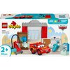 Pudełko zestawu LEGO DUPLO przedstawia kolorową scenę z warsztatu, w której znajduje się czerwony samochód z numerem 95 oraz różne akcesoria warsztatowe. Na opakowaniu widnieją napisy: "LEGO duplo", "10456 McQueen's Visit to Doc's Garage", "2+ 35 pcs", "L