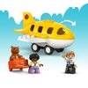 Zestaw LEGO przedstawia kolorową wieżę kontrolną z niebieskimi i żółtymi elementami oraz zjeżdżalnię. Na wieży znajduje się symbol czerwonego samolotu z żółtymi skrzydłami, a obok widoczny jest miś i walizka z rysunkiem misia.