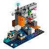 Na zdjęciu znajduje się zestaw klocków LEGO przedstawiający scenę z gry Minecraft, zbudowany z różnokolorowych elementów, w tym szarych, niebieskich, pomarańczowych i zielonych. Widoczny jest napis "TNT" na jednym z klocków oraz elementy przypominające wo