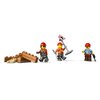 Na zdjęciu znajdują się trzy figurki LEGO w kaskach budowlanych, jedna z nich trzyma znak ostrzegawczy, a obok nich leży stos klocków przypominających drewniane belki. Wszystkie elementy są częścią zestawu LEGO City.