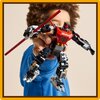 Na zdjęciu widoczny jest model LEGO przedstawiający mecha z czerwonymi i czarnymi elementami oraz mieczem świetlnym. W tle znajduje się osoba w niebieskim ubraniu, trzymająca model w dłoni.