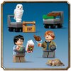 Na zdjęciu znajdują się klocki LEGO przedstawiające dwie figurki postaci z serii Harry Potter, trzymające akcesoria, oraz białą sowę siedzącą na wózku z walizką oznaczoną literami "HP". Obok widoczny jest szary wózek z klockami oraz mała figurka brązowego