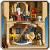 Na zdjęciu znajduje się zestaw klocków LEGO przedstawiający wnętrze zamku z serii Harry Potter, z widocznymi figurkami, schodami i detalami architektonicznymi. W tle widać niebieskie niebo, a na górnym poziomie znajduje się figurka z długą białą brodą ora
