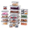 Na zdjęciu znajduje się zestaw 24 przezroczystych pojemników na żywność z pokrywkami i uszczelkami, wypełnionych różnymi produktami spożywczymi, takimi jak płatki, fasola, makaron, ciasteczka i orzechy. Pojemniki są ułożone w kilku stosach, różnią się wielkością i kształtem.