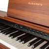 Na obrazie widoczne jest cyfrowe pianino w kolorze brązowym z wyraźnym logo "MUSICMATE" na drewnianej obudowie. Panel sterowania zawiera przyciski z napisami: "POWER", "VOLUME", "TONE", "RHYTHM", "DEMO", "SELECT", "RECORD", "PLAY", "TOUCH", "TRANSFER" ora