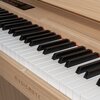 Na obrazie widoczne jest cyfrowe pianino z klawiaturą w kolorze czarnym i białym, umieszczone na drewnianej obudowie. Na froncie obudowy znajduje się napis "MUSICMATE".