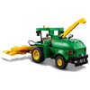 Zestaw klocków LEGO przedstawia zieloną maszynę rolniczą z żółtymi kołami i ruchomym ramieniem. Na maszynie widoczny jest napis "John Deere" oraz logo marki.