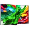 Na zdjęciu widoczny jest telewizor z dużym, kolorowym wyświetlaczem, na którym prezentowane są abstrakcyjne wzory w intensywnych barwach zieleni, niebieskiego, czerwieni i żółci. Telewizor ma cienką ramkę i stoi na prostokątnej podstawie.