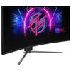 Zakrzewiony monitor z logo "MSI" na dolnej ramce, wyświetlający kolorową grafikę z neonowymi liniami i logo "MPG" oraz napisem "MSI PERFORMANCE GAMING". Monitor stoi na metalowej podstawie z trzema nogami.