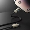 Czarny kabel USB-C - Lightning z wyświetlaczem LCD pokazującym "12V" jest podłączony do urządzenia z widocznymi ikonami latarki i aparatu. Kabel ma plecioną osłonę i jasne złącza.