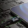 Zbliżenie na kabel USB-C podłączony do urządzenia elektronicznego, z widocznym wnętrzem wtyczki i zielonymi liniami świetlnymi wokół. Tło przedstawia wzór przypominający obwody elektroniczne.