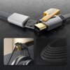Na zdjęciu widoczny jest czarny kabel USB-C/USB - USB-C/Lightning z oznaczeniem "65W" oraz "PD 2.1W MAX" na tle wzoru przypominającego obwody elektroniczne. Dodatkowo, w dolnej części zdjęcia znajdują się dwa mniejsze obrazy przedstawiające zbliżenie na końcówkę kabla oraz teksturę jego oplotu.