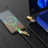 Na zdjęciu widać smartfon z wyświetlaczem pokazującym "98.1% Super charging" oraz laptopa, do których podłączony jest czarny kabel USB-C/USB - USB-C/Lightning VEN-DENS 65W 1.2 m. Na kablu widoczne są napisy "ven-dens" oraz "PD 72W MAX".