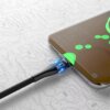 Czarny kabel USB-C - USB-C VEN-DENS LED 60W 1.5 m jest podłączony do smartfona, na którym wyświetla się godzina 16:35 oraz napis "Super charging 99%". W tle widoczny jest wzór przypominający obwody drukowane.