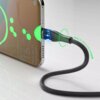Na zdjęciu widać telefon z podłączonym kablem USB-C, który ma wyświetlacz LED pokazujący napięcie i natężenie prądu. Na ekranie telefonu widoczny jest tekst: "Super charging 98%", "Wed, Apr 21", a obok kabla napis "BOLD PROTECTION".