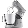 Na zdjęciu znajduje się srebrny robot kuchenny planetarny z dużą metalową misą i przymocowanym mieszadłem. Na obudowie widoczny jest napis "KENWOOD" oraz "TITANIUM CHEF BAKER XL".