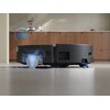 Czarny robot sprzątający ECOVACS Deebot T80 Omini jest widoczny z boku na podłodze, z grafiką wskazującą prędkość 200 rpm. W tle znajduje się kuchnia z drewnianymi szafkami i dekoracjami.