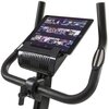 Czarny rower magnetyczny z uchwytem na tablet, na którym wyświetlane są miniatury różnych programów i filmów. Kierownica roweru ma wbudowane sensory dotykowe.