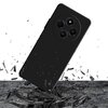 Czarne etui na telefon z trzema okrągłymi wycięciami na aparaty, unosi się nad powierzchnią, z której unoszą się fragmenty materiału. Na jednym z obiektywów widoczny jest napis "50 MP".