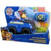 Opakowanie z zabawką przedstawia niebieski zdalnie sterowany samochód z figurką psa w mundurze policyjnym, obok znajduje się pilot do sterowania. Na opakowaniu widnieje logo "PAW Patrol" oraz napisy: "RC Action Cruiser", "Véhicule de Sauvetage Radiocomman
