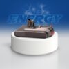 Na zdjęciu znajduje się akumulator w kolorze szarym, umieszczony na białym, okrągłym postumencie. W tle widoczny jest napis "ENERGY" z efektem błyskawic na niebieskim tle.