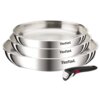 Na zdjęciu widoczny jest zestaw trzech stalowych patelni z logo "Tefal" na boku każdej z nich oraz odłączana rączka z czarnym uchwytem i czerwonym przyciskiem. Patelnie są ułożone jedna na drugiej, a rączka leży obok nich.