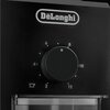 Czarny panel młynka do kawy z logo "DeLonghi" na górze, poniżej znajduje się pokrętło z oznaczeniami liczbowymi od 2 do 12 oraz ikoną filiżanki.
