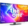 Telewizor z kolorowym ekranem wyświetlającym abstrakcyjne wzory w odcieniach fioletu, niebieskiego, pomarańczowego i czerwonego, z widocznymi napisami: "AMBILIGHT tv", "PHILIPS", "the one" oraz "QLED". Urządzenie stoi na prostokątnej podstawie.