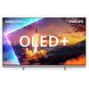 Telewizor z widocznym ekranem przedstawiającym start rakiety na tle górskiego krajobrazu o zachodzie słońca, z dużym napisem "OLED+" na środku. W lewym górnym rogu widnieje napis "AMBILIGHT tv", a w prawym górnym rogu logo "PHILIPS".