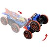 Zdalnie sterowany samochód Hot Wheels Monster Trucks Shark Wspinacz JFR39 z dużymi, pomarańczowymi kołami i niebiesko-pomarańczową karoserią w kształcie rekina. Na oponach widoczny jest napis "Hot Wheels", a czerwone strzałki wskazują kierunek ruchu pojaz