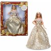 Na zdjęciu znajduje się lalka w eleganckiej, złotej sukni z wzorem, umieszczona w ozdobnym opakowaniu z napisem "Holiday Barbie 2023". W dolnym rogu opakowania widnieje logo "Barbie Signature".