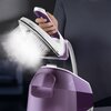 Osoba trzyma generator pary w kolorze fioletowym, z którego wydobywa się strumień pary. Na urządzeniu widoczny jest napis "BRAUN CareStyle 5" oraz oznaczenie pojemności "2.3L".