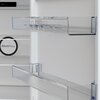Na zdjęciu widoczna jest duża kartonowa paczka z napisem "REFRIGERATOR" transportowana po schodach przez dwie osoby w uniformach. W tle znajduje się ceglana ściana budynku, a na żółtym tle wokół zdjęcia umieszczono tekst: "W Media Expert dbamy o Twoją wyg