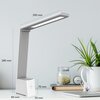 Na zdjęciu znajduje się biała i szara lampka biurkowa o nowoczesnym designie, z widocznymi wymiarami: 280 mm wysokości, 200 mm długości ramienia, 80 mm szerokości podstawy i 50 mm głębokości. Obok lampki na biurku znajdują się roślina w białej doniczce, s